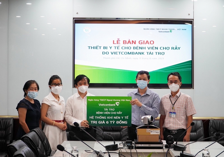 Phó Tổng Giám đốc Đặng Hoài Đức (thứ 3 từ trái sang) trao biểu trưng tặng quà cho đại diện Bệnh viện Chợ Rẫy, thầy thuốc ưu tú, Bác sĩ CKII Nguyễn Tri Thức (thứ 2 từ phải sang) – Giám đốc Bệnh viện